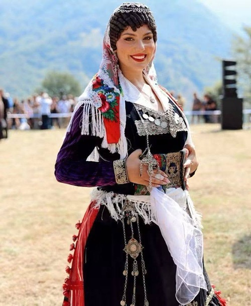 Në Logun e Bjeshkëve, në tokën e zanave, e Bukura e Dheut, nga qielli zbret, stolisur me hir e veshur me xhubletë